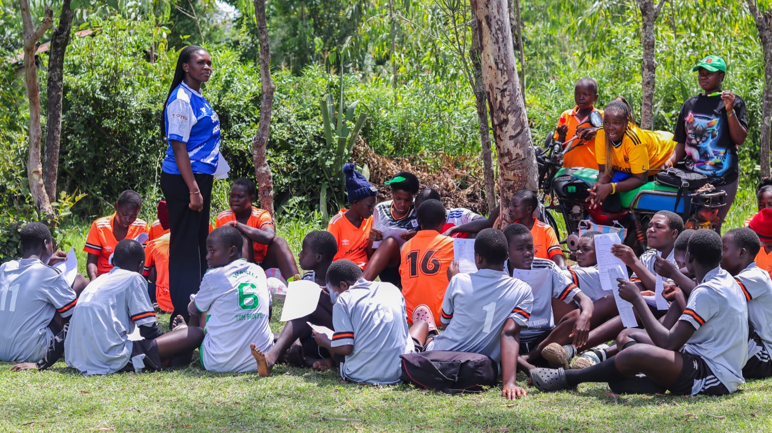 A community health worker speaks with a small group of young women.